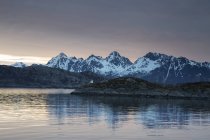 Ruhiger Blick auf schneebedeckte Berge jenseits des Fjords, maervoll, erhaben, norwegisch — Stockfoto
