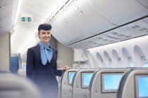 Портрет улыбающейся, уверенной в себе стюардессы в самолете — стоковое фото