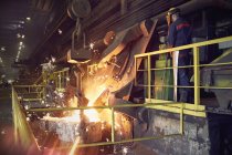 Сталевий працівник на платформі над розплавленою піччю в сталеливарному заводі — стокове фото