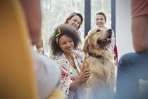 Frau streichelt Hund in Gruppentherapie — Stockfoto