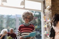 Retrato sorrindo sênior mulher ler livro na loja — Fotografia de Stock