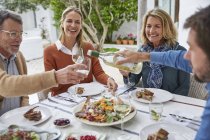 Coppie che bevono vino bianco e pranzano sul patio — Foto stock