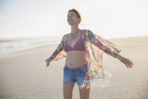 Donna spensierata che cammina sulla soleggiata spiaggia estiva — Foto stock