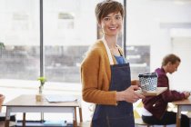 Portrait confident female cafe owner serving coffee on tray in cafe — Stock Photo