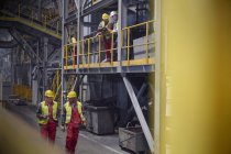 Trabajadores siderúrgicos hablando y caminando en la fábrica de acero - foto de stock