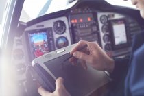 Airplane pilot using stylus on digital tablet in cockpit — Stock Photo
