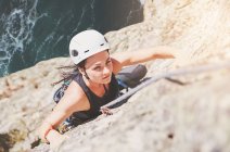 Konzentrierte, entschlossene Bergsteigerin erklimmt Fels — Stockfoto