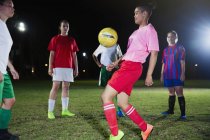 Young female soccer players practicing on field at night — Stock Photo