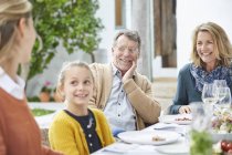 Famiglia multigenerazione che si gode il pranzo al tavolo del patio — Foto stock