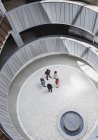 Blick von oben Geschäftsleute unterhalten sich im runden, modernen Büro-Atriumhof — Stockfoto