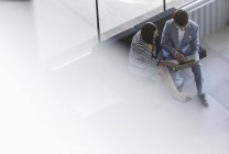 Geschäftsfrau und Geschäftsfrau arbeiten, teilen Laptop in Büro-Lobby — Stockfoto