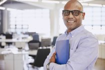 Portrait smiling businessman at modern office — Stock Photo