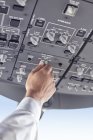 Pilot justiert Kontrollinstrumente im Flugzeug-Cockpit — Stockfoto
