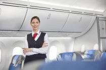 Портрет усміхненої, впевненої жінки-консультантки польоту на літаку — стокове фото