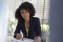 Smiling businesswoman explaining paperwork in meeting — Stock Photo