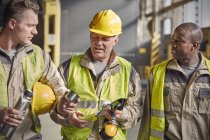 Steelworkers with insulated drink container taking coffee break in steel mill — Stock Photo