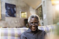 Portrait smiling, confident senior man on sofa — Stock Photo