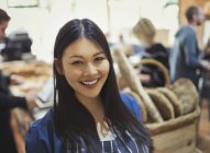 Retrato sonriente mujer joven en la tienda de comestibles - foto de stock