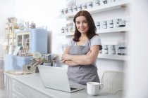 Portrait confident, smiling art shop business owner standing at counter — Stock Photo