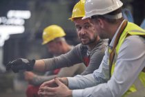 Männliche Arbeiter reden in Fabrik — Stockfoto