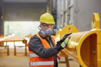 Male worker wearing protective mask in factory — Stock Photo