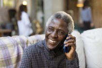 Улыбающийся пожилой человек разговаривает по смартфону — стоковое фото
