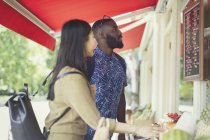 Young couple shopping for produce, looking at prices at outdoor market — Stock Photo