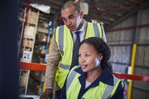 Manager and worker working in distribution warehouse — Stock Photo