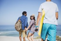 Família caminhando com prancha de boogie na ensolarada praia do oceano de verão — Fotografia de Stock