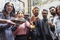 Friends with sparklers and cake celebrating at party — Stock Photo