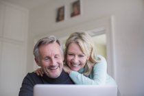 Sorridente, felice coppia matura utilizzando il computer portatile — Foto stock