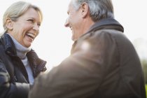 Mature caucasian couple hugging at park and looking at each other — Stock Photo