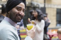 Porträt lächelnder Mann im Turban trinkt und genießt Party — Stockfoto