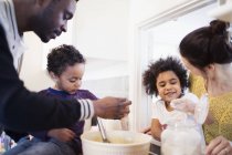 Happy multiracial family baking in kitchen — Stock Photo