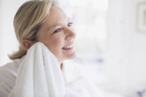 Sorrindo mulher madura secando rosto com toalha — Fotografia de Stock
