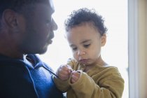 Père afro-américain tenant petit fils — Photo de stock