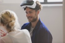 Programmatore di computer sorridente che indossa occhiali da simulatore di realtà virtuale — Foto stock