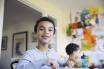 Portrait confident boy eating at dining table — Stock Photo