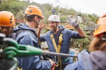 Enthusiastic man preparing to zip line, gesturing peace sign — Stock Photo