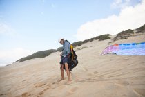 Male paraglider preparing equipment on beach — Stock Photo