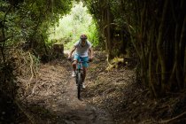 Uomo maturo mountain bike sul sentiero nel bosco — Foto stock