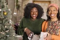 Портрет улыбается, восторженная мать и дочь открывают рождественский подарок — стоковое фото