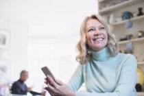 Sorridente, donna matura fiduciosa utilizzando lo smartphone — Foto stock