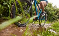 Donna mountain bike sul sentiero fangoso — Foto stock