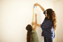 Mutter und Tochter messen Wand für Projekt — Stockfoto