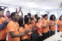 Hackers felices animando y celebrando, codificando para caridad en hackathon - foto de stock