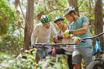 Amigos mountain bike, usando câmera wearable na floresta — Fotografia de Stock