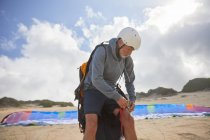 Male paraglider preparing on sunny beach — Stock Photo