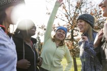 Жінки бігуни розтягуються і розмовляють в сонячному парку — стокове фото