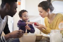Genitori e curiosi bambino figlio cottura in cucina — Foto stock